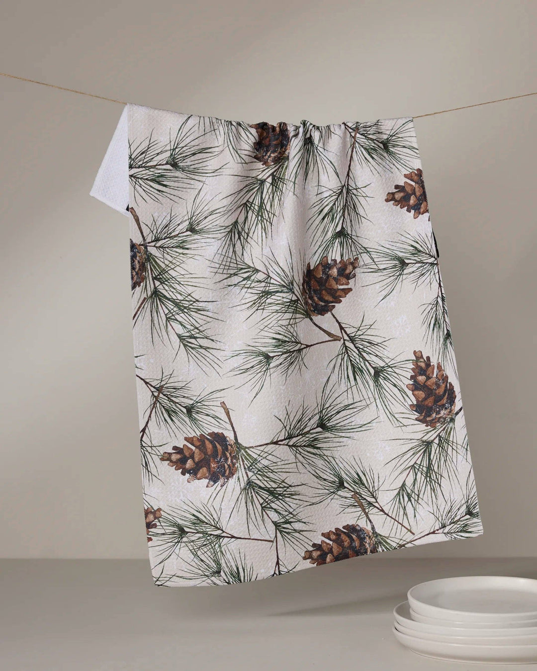 Geometry Evergreen Frost Tea Towel featuring pine branches and pinecones on white