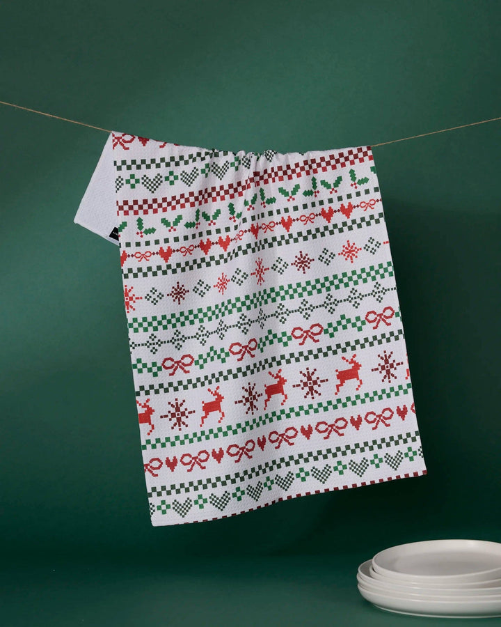 Geometry Ugly Sweater Day Tea Towel featuring red and green sweater-style rows of reindeer, hearts, bows and snowflakes